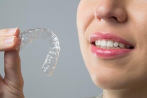 woman holding Invisalign tray