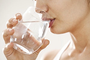 Woman sipping a glass of water.