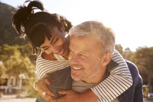 A woman with her arms around a man's shoulders and smiling