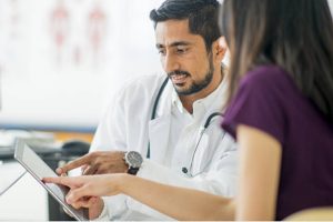 A doctor showing his patient something on a tablet