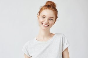 A young woman smiling in front of a white background