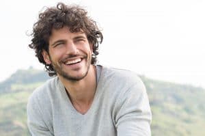 A young man smiling and looking into a distance