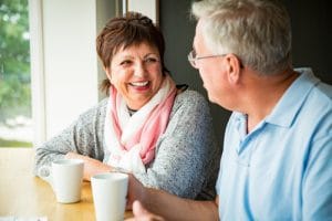 A womand and man talking and enjoying coffee together